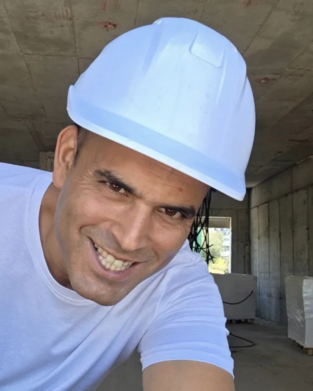 יאיר אלה עם קסדה לבנה בתוך מבנה בבנייה